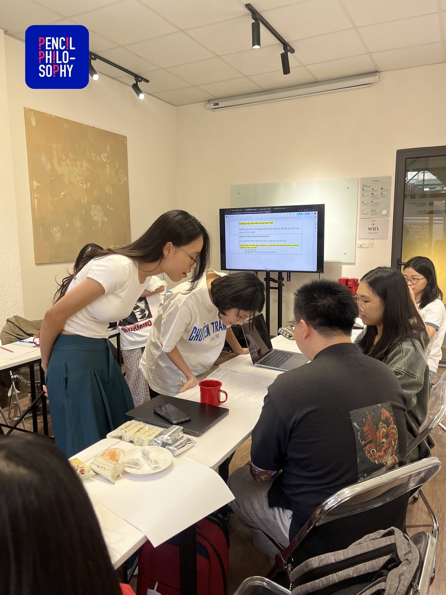 Học viên tụ lại quanh màn hình trong hoạt động nhóm