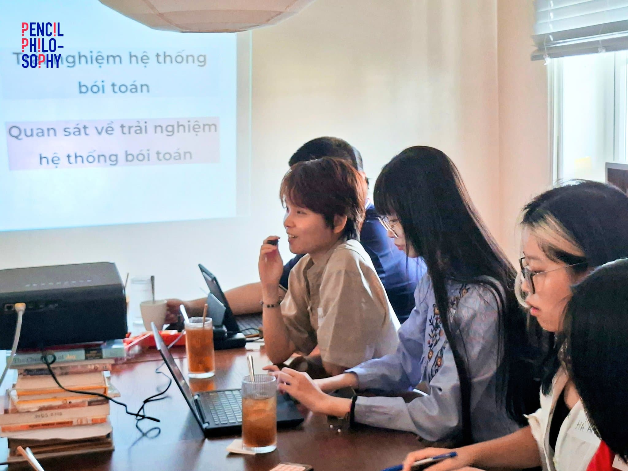 Hội viên ngồi trước màn chiếu slide Trải nghiệm hệ thống bói toán