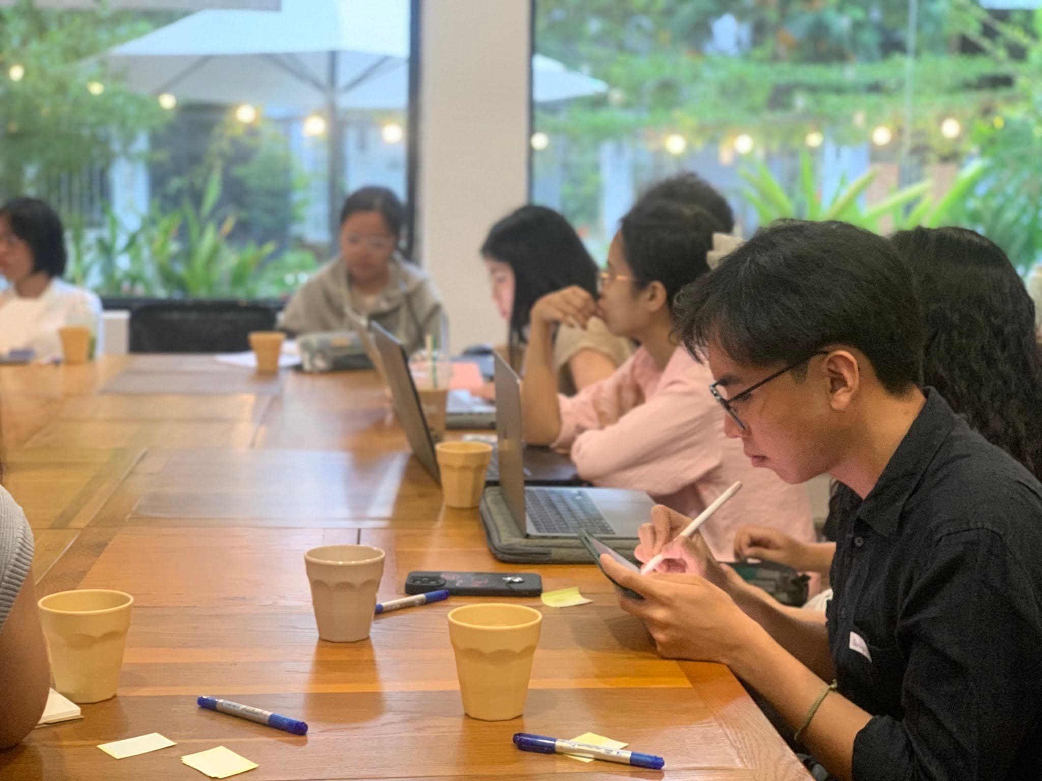 Học viên ghi chép và thảo luận quanh bàn dài trong giờ seminar